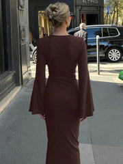 Woman in a brown dress walking on a city street