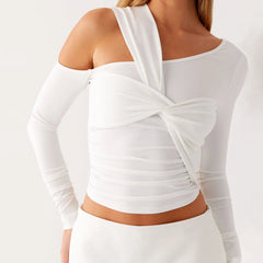 A full-length shot of a women's asymmetrical tee styled for a night out.