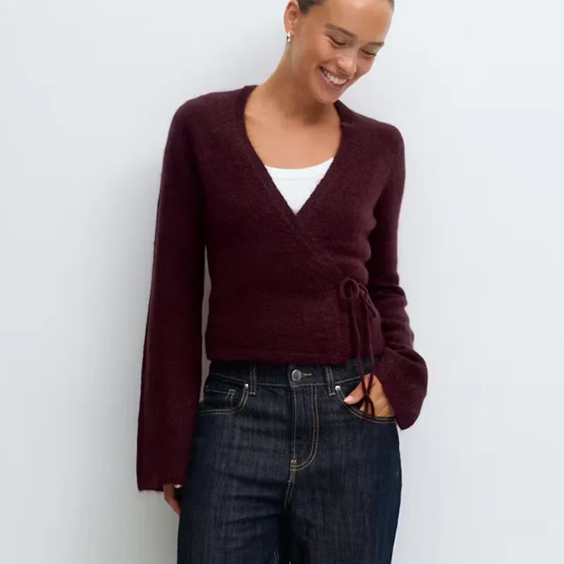 A front view of a women's casual V-neck top, highlighting the side tie detail.