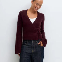A front view of a women's casual V-neck top, highlighting the side tie detail.