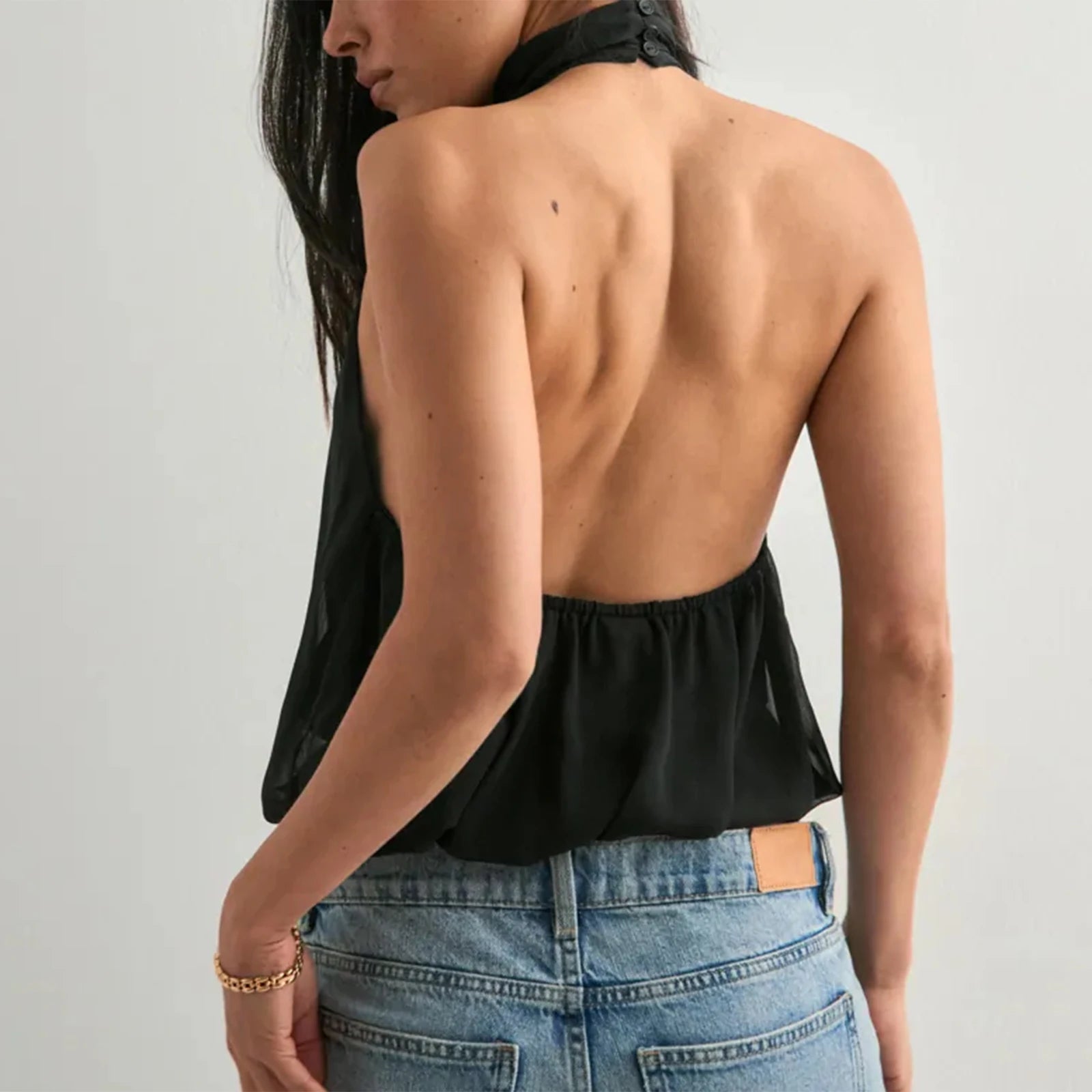 A full-length shot of a women's halter top styled for a summer day.