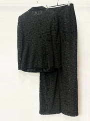 Black lace outfit on a hanger against a white background