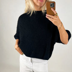 A women's regular-fit knit shirt styled with jeans.
