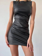 Close-up of PU leather mini dress with fitted silhouette dress worn by a model on a plain background