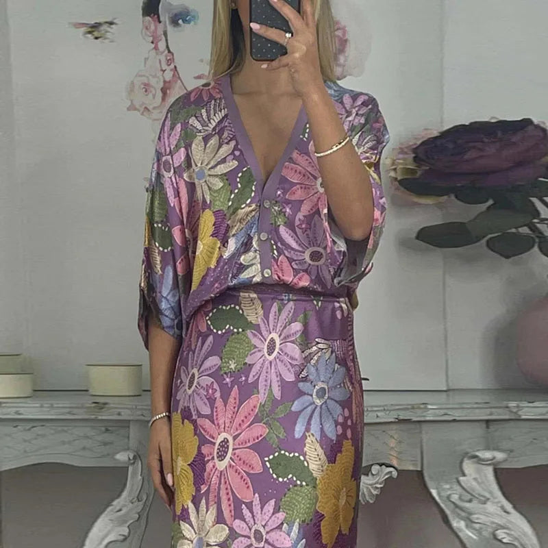 Person wearing a floral satin ankle-length skirt with an elastic waist, with a blurred background.