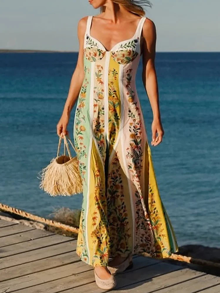 Close-up of a woman in a patchwork print on a summer maxi dress standing on a wooden dock by the ocean.