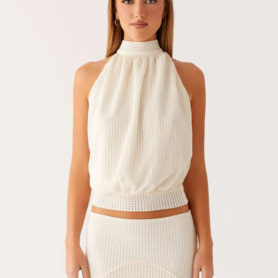 Woman wearing a Y2K cropped broadcloth women’s top with a tie neckline for a modern style top and skirt set on a plain background