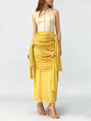 Woman wearing a high-waist yellow draped knot midi skirt.