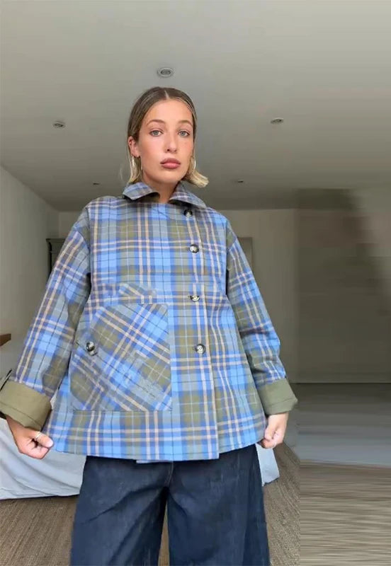 Person wearing a blue plaid coat in an indoor setting