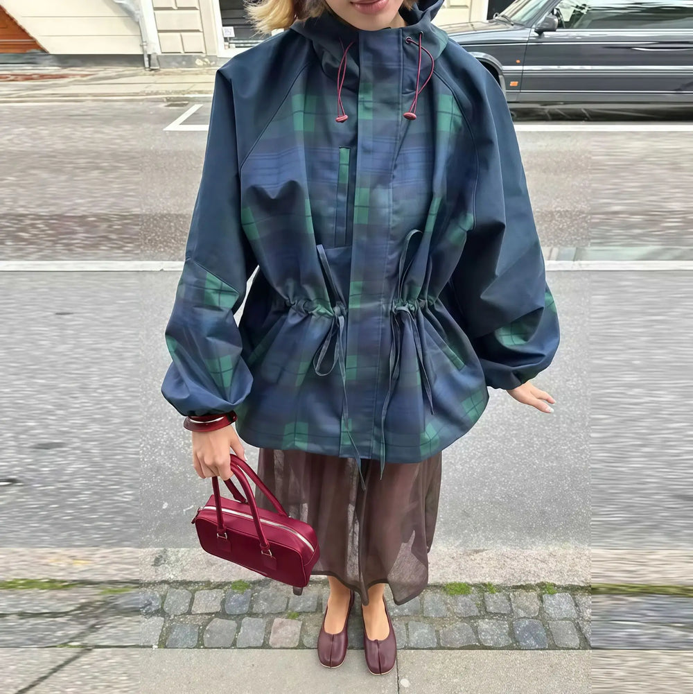 Person wearing a blue plaid raincoat on a street