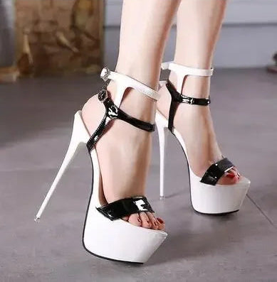 White high-heeled platform shoes with black accents on a neutral background