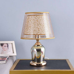  Golden Atelier 3D fireworks table lamp with a glass enclosure filled with intricate lighting elements that create a 3D fireworks effect. The lamp has a base with up-down lighting controls, displayed on a table in a living room setting. Rice White 2