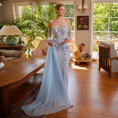 A woman wearing an elegant floral and feather mermaid gown with a sweetheart neckline.