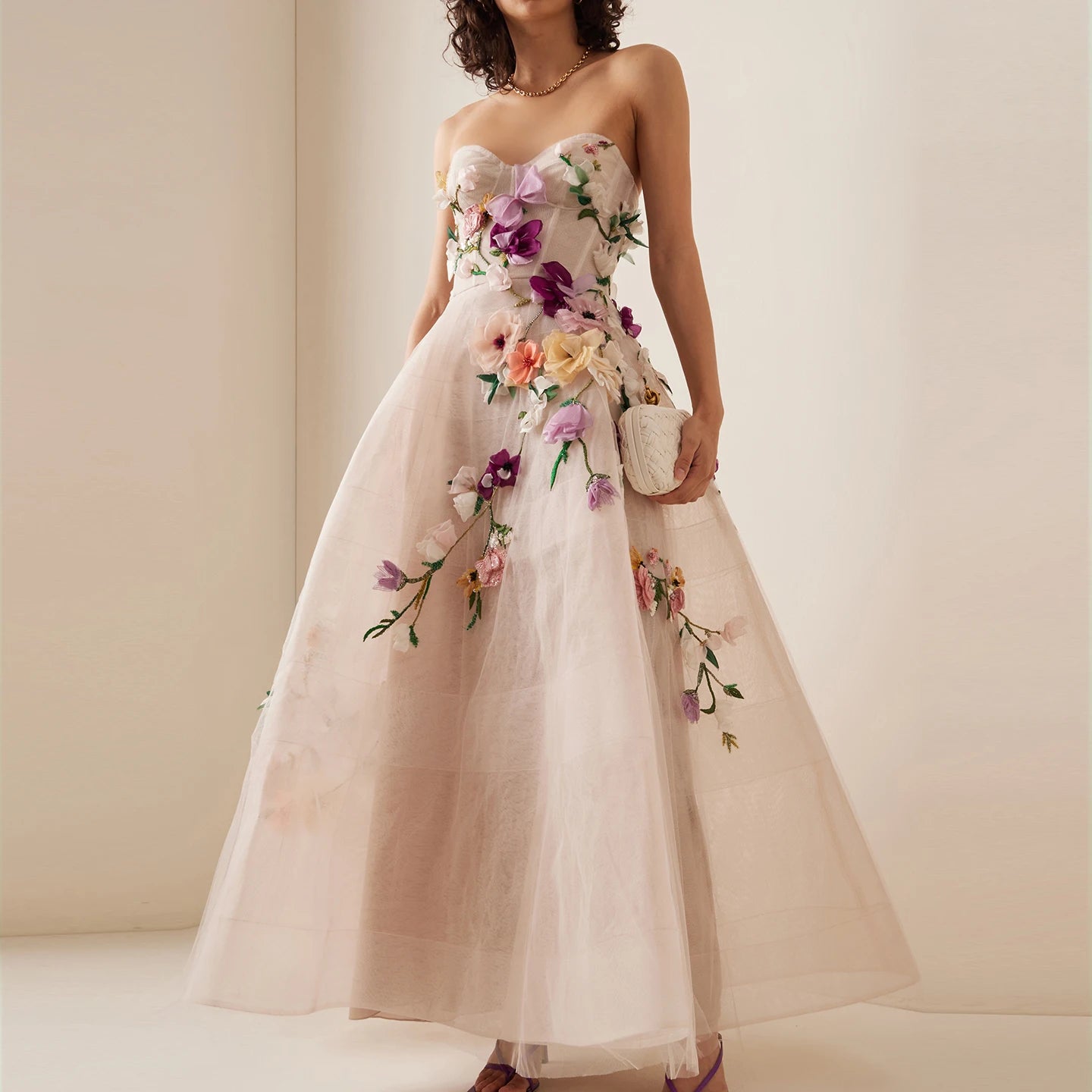 A woman wearing an elegant 3D floral midi gown with a sweetheart neckline.