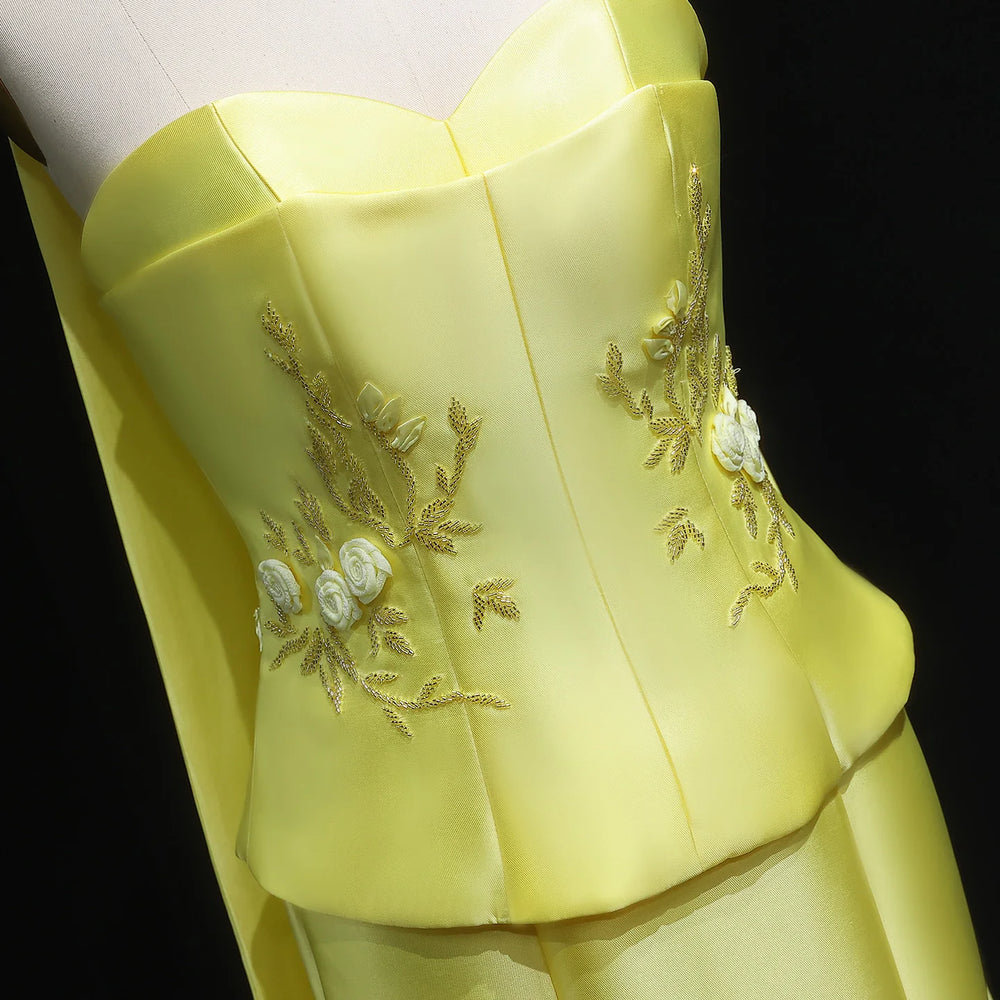 Yellow dress with floral embroidery on a black background