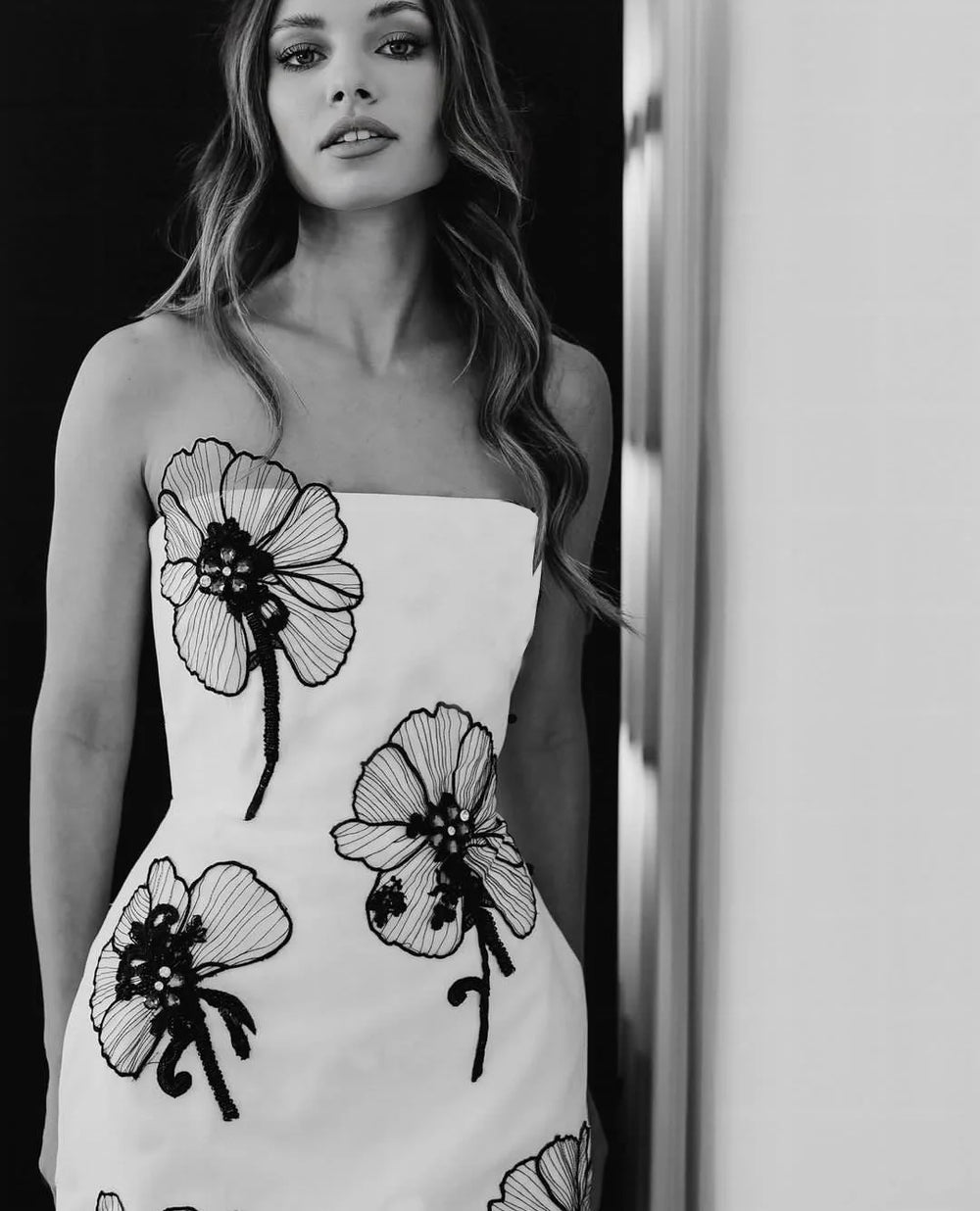 Strapless white mini dress with black floral appliqué