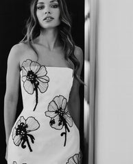 Strapless white mini dress with black floral appliqué
