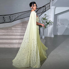 Woman in a light green saree standing in a elegant interior setting