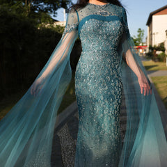 A model wearing the turquoise crystal mermaid evening gown, showcasing its flattering silhouette and graceful train. Golden Atelier 3