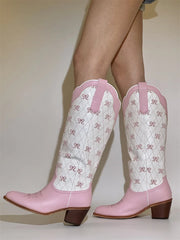 Pink cowboy boots with white pattern on a plain background