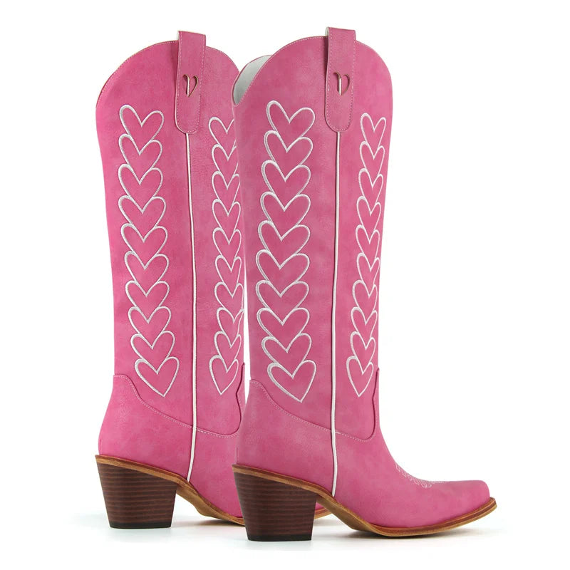 Pair of pink western boots with white heart embroidery, showing heel