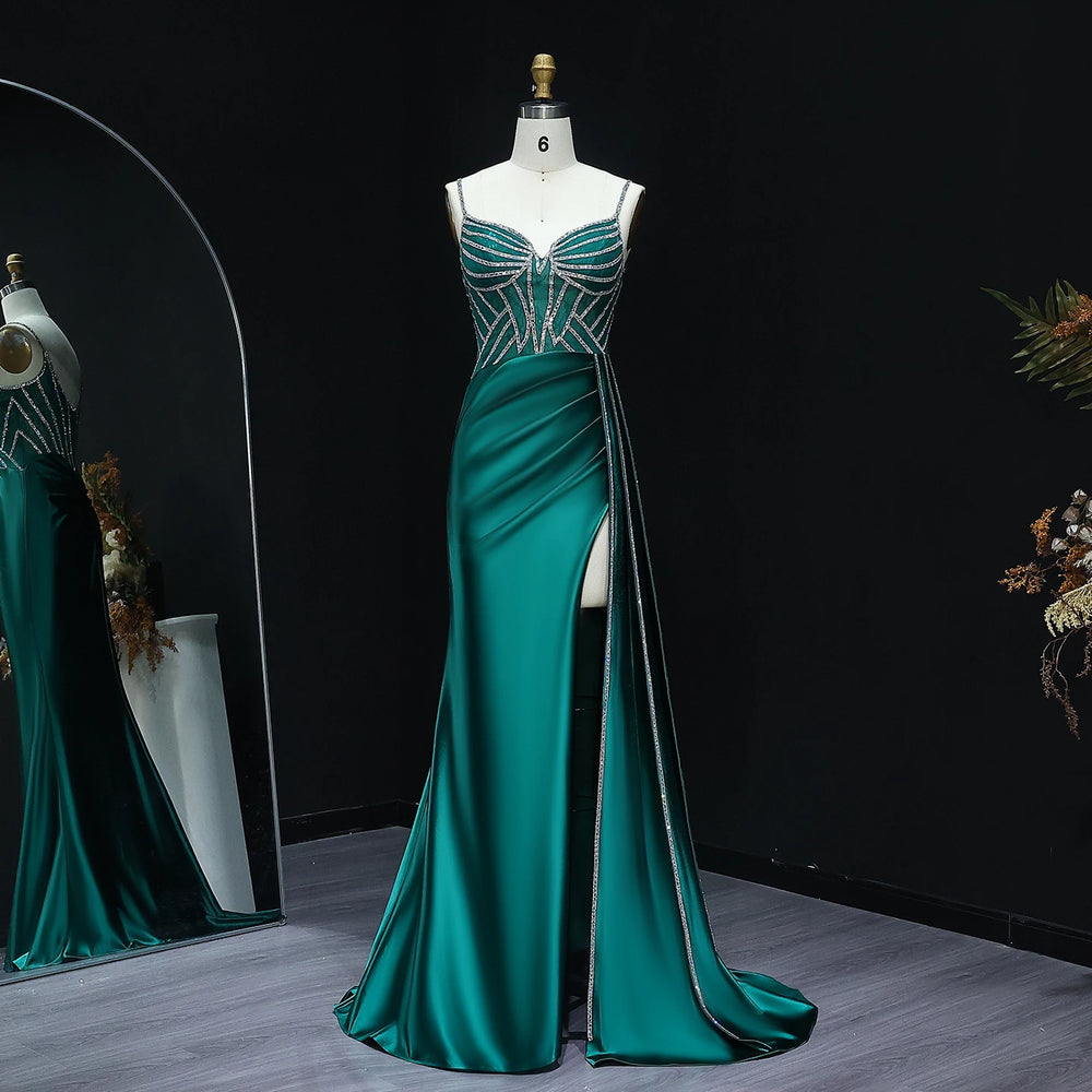 Teal evening gown with silver embellishments on a mannequin against a dark background.