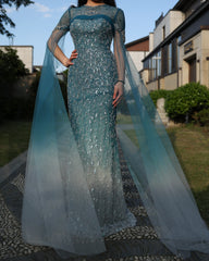 A model wearing the turquoise crystal mermaid evening gown, showcasing its flattering silhouette and graceful train. Golden Atelier 2