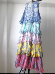Multicolored floral dress with ruffled layers on a stand against a white background