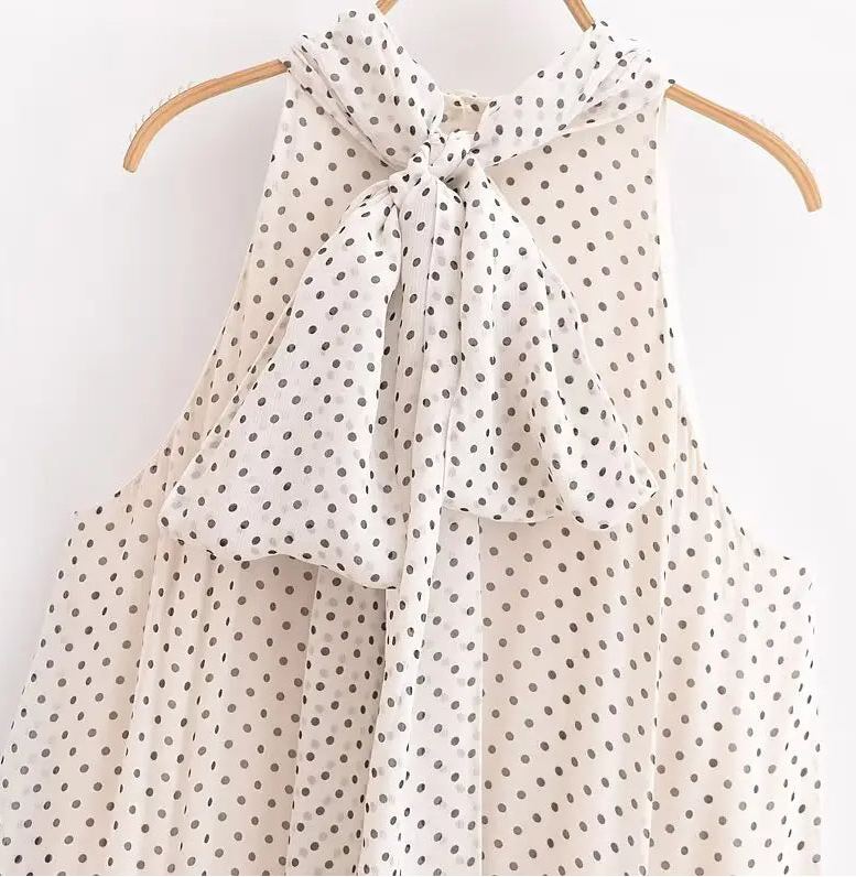 Beige polka dot scarf on a wooden hanger against a white background