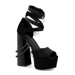 Black high-heeled platform shoe with ankle strap and heart charms on a white background
