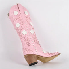 Pink cowboy boot with floral embroidery on a light gray background