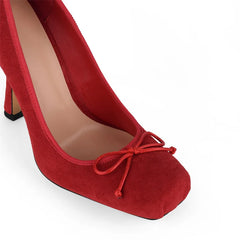 Red high-heeled shoe with a bow on a white background