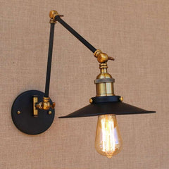 An adjustable swing arm wall-mounted LED light fixture with a black shade and brass accents.