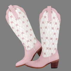 Pink cowboy boots with white patterned insoles on a gray background