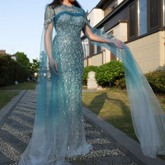 A model wearing the turquoise crystal mermaid evening gown, showcasing its flattering silhouette and graceful train. Golden Atelier 4