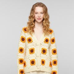 Woman wearing a sunflower-patterned cardigan against a plain background