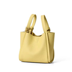 A faux leather bucket crossbody bag in yellow colour with an adjustable strap and drawstring closure.