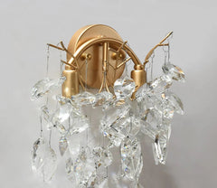 Gold wall sconce with crystal accents on a gray background