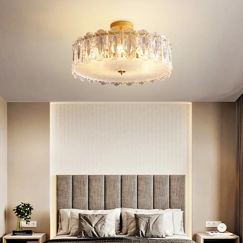 Modern bedroom with a crystal ceiling light fixture, bed, and nightstands.