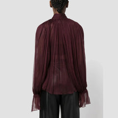Maroon sheer blouse worn by a person on a white background