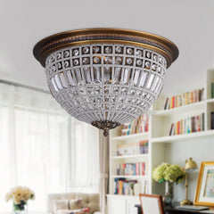 Decorative ceiling light fixture in a room with bookshelves and a couch.