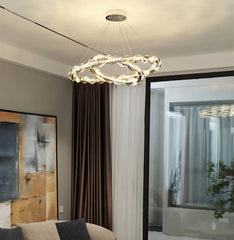 Modern living room with a chandelier, sofa, and coffee table.