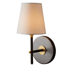 A stylish mid-century modern wall lamp with a fabric shade, casting a warm glow in a room.