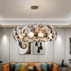 A stunning crystal chandelier with a wrought iron frame, hanging above a living room table.