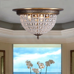 Decorative ceiling light fixture in a room with a window view of flowers and sky.