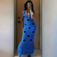 Person wearing a blue dress with black polka dots in a mirror selfie.
