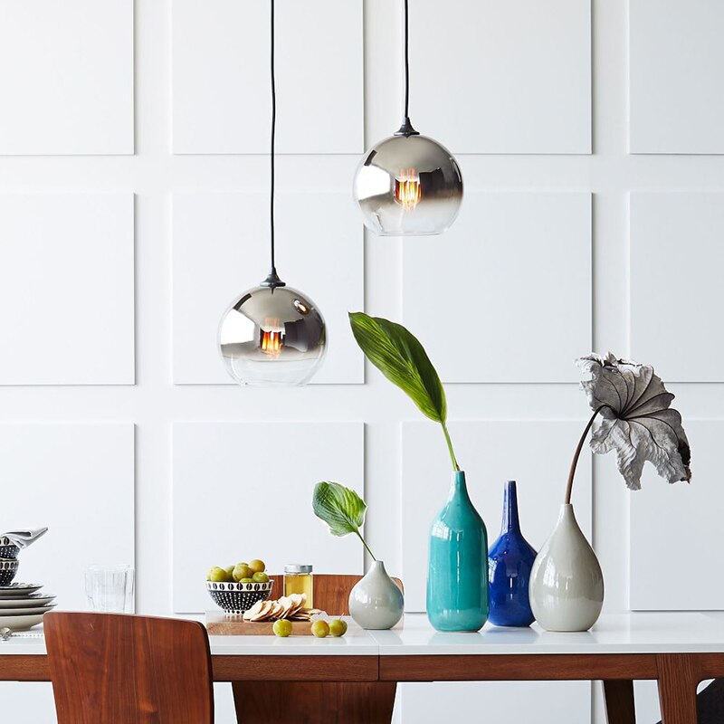 Two pendant glass ball luminaire suspension E27 lights with  silver finish  suspended over a dinning table.