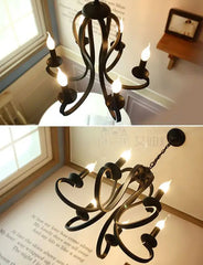 Black chandelier with lit candles on a book background