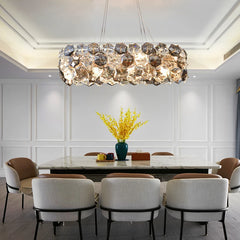 A stunning crystal chandelier with a wrought iron frame, hanging above a dining room table.