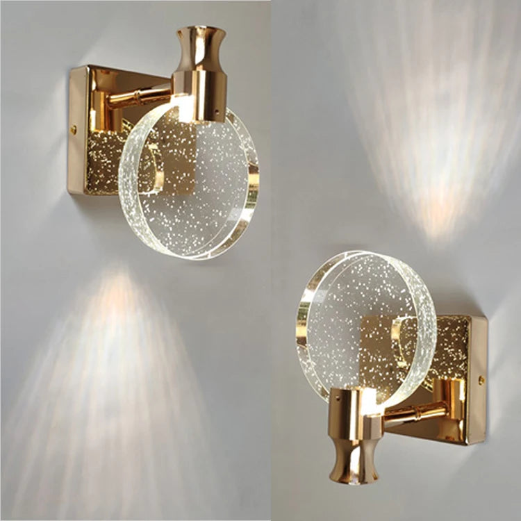 Two gold wall sconces with glass shades on a light gray background